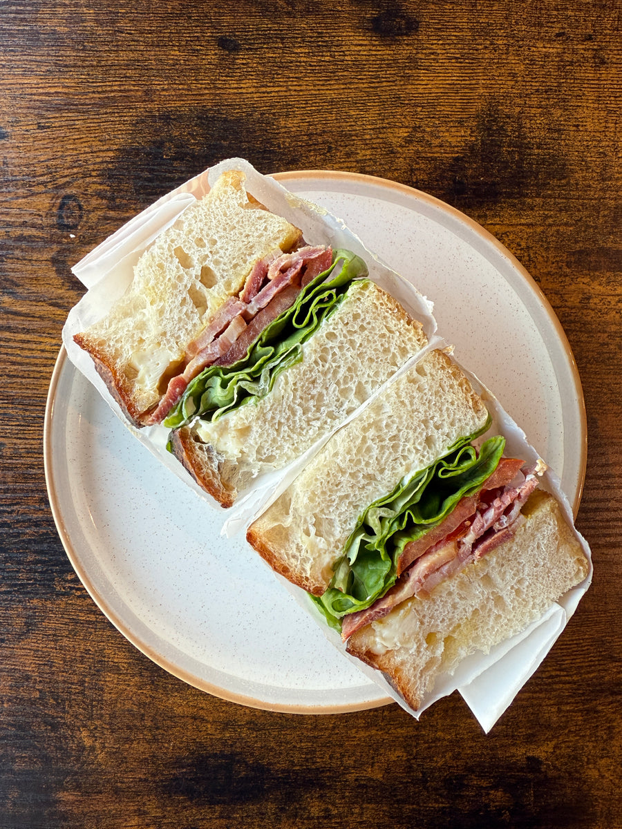 BLT sandwich on white bread with bacon and crisp lettuce, served on a plate at Krumb Bakery, Belfast
