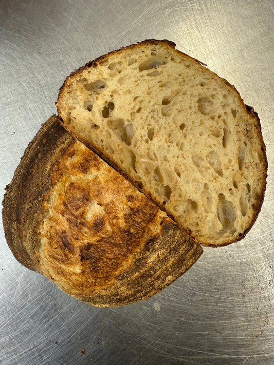 Seeded sourdough loaf from Krumb Bakery Belfast, dark crackled crust encrusted with seeds, baked fresh on the Ormeau Road